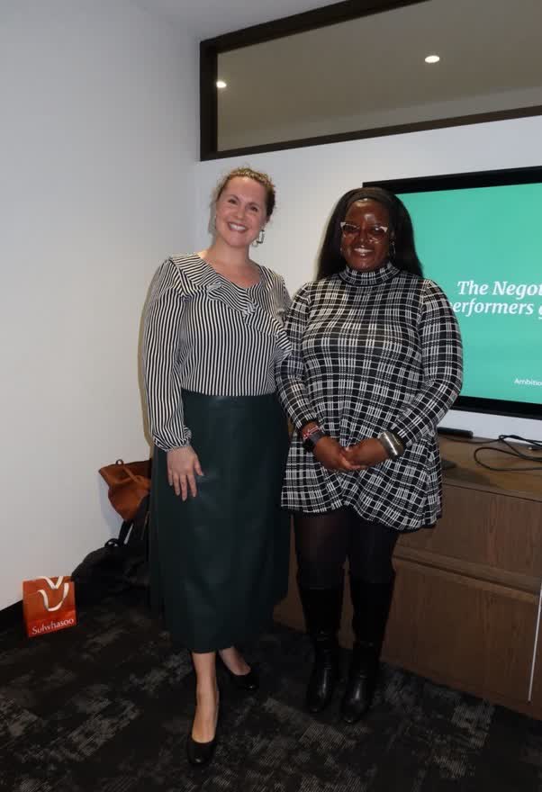 Two speakers smiling together at the negotiation event