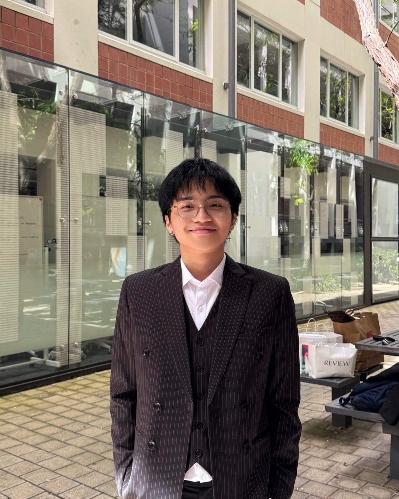 A smiling young professional in a pinstripe suit
