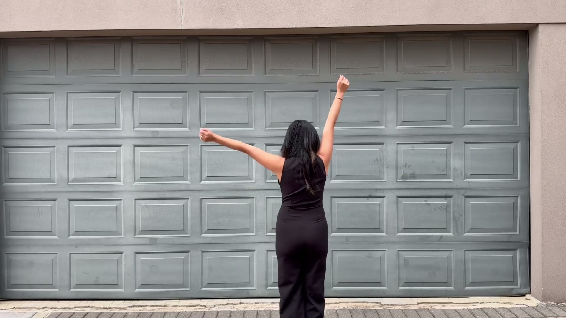 A guest in a black dress celebrating with her arms raised