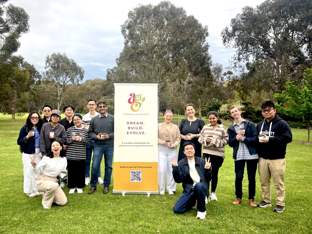 The Ambitious Growth Circle community gathered in a park with the AGC banner